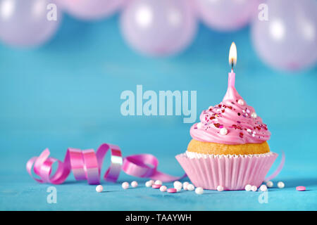 Happy birthday cupcake with candle. Pink birthday cake background card with balloons. Stock Photo