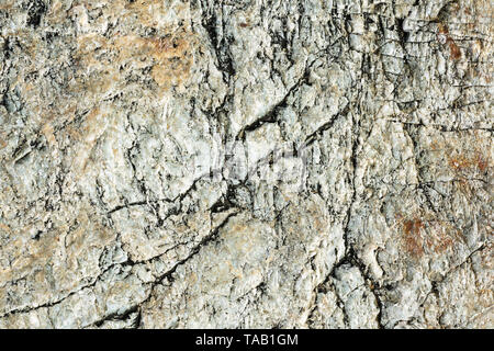Macro view of cracked stone surface brown and grey color. Detailed nature background or pattern texture taken in natural environment. Weathered over y Stock Photo