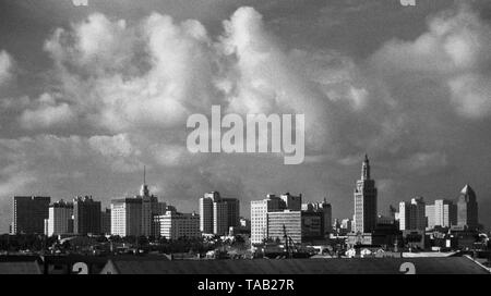 AJAXNETPHOTO. SEPTEMBER, 1963. MIAMI, FLA, USA. - DOWNTOWN MIAMI - THUNDERY CLOUDS BUILDING OVER THE CITY SKYLINE. TALLEST BUILDING (CENTRE, RIGHT.) IS MIAMI DADE COUNTY COLLEGE FREEDOM TOWER, NOW (21ST CENTURY) PART OF MUSEUM OF ART AND DESIGN COMPLEX. PHOTO:JONATHAN EASTLAND/AJAX REF:M1206311 1 2 Stock Photo