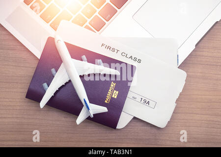 Two tickets are on the table with a laptop. buying online ticket booking for travel concept Stock Photo