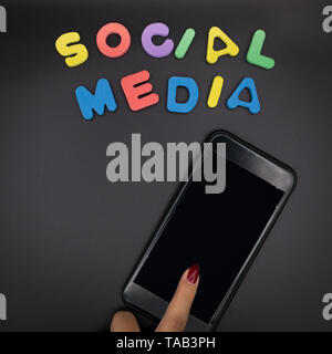 woman using phone with social media letters , smart phone on black background. Stock Photo