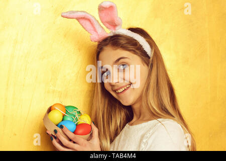 happy easter girl in bunny ears with colorful painted eggs Stock Photo