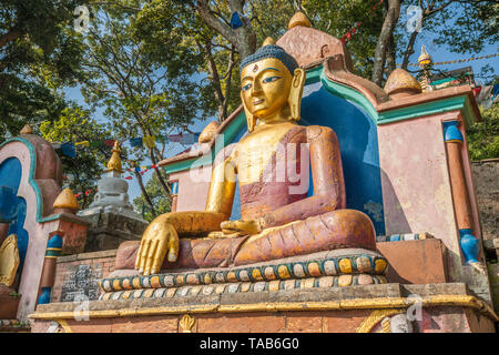 Golden Buddha statue at the base of the Monkey Temple, also known as Swayambhunath Stupa, Kathmandu, Nepal Stock Photo