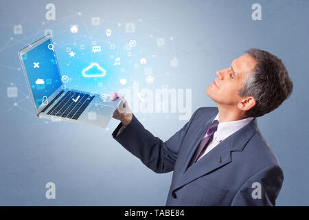 Man holding laptop projecting notifications, symbols and information based on cloud technology system  Stock Photo