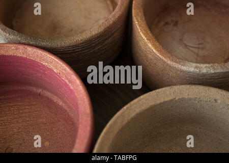 Four textured concrete pots spray painted in beige and pink colors with golden glitters close-up Stock Photo