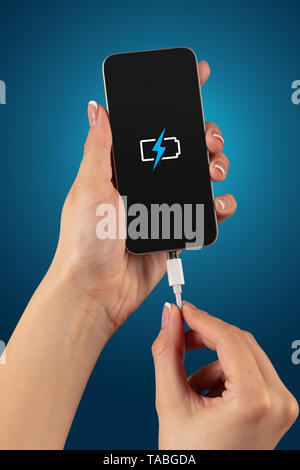 Elegant hand charging cellphone with low battery  Stock Photo