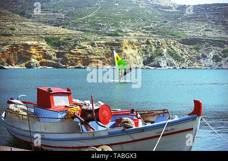 Ayios Nikolaos beach near Agkali, Folegandros, Greece, with fishing-boat and windsurfer.  MODEL RELEASED Stock Photo