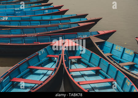 High angle view of many red and blue row boats moored at a dock. Stock Photo