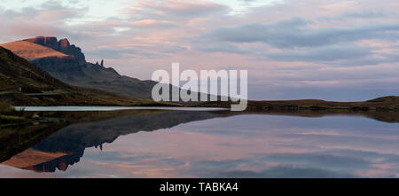 Peaceful and serene reflective view of rolling hills rising from a still lake. Stock Photo