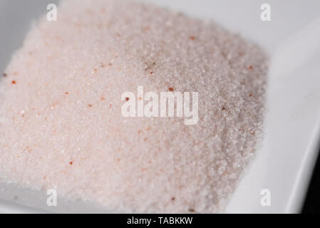 pink Hymalaia salt in a square white ceramic bowl, macro details Stock Photo
