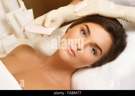 Beautiful woman in professional beauty spa salon during ultrasonic facial cleansing procedure Stock Photo