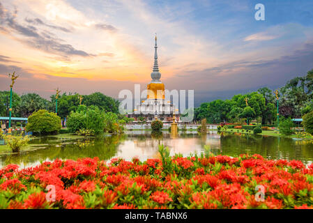 Mahasarakham Thailand - 2018 September 21: Phra That Na Dun pagoda Thailand with red flower and beautiful sky sunset stupa that buddhism worship and l Stock Photo