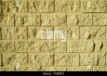 Background from a decorative imitation of a bricklaying of light yellow color. Industrial and general application. Stock Photo
