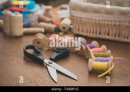 Sewing concept. Scissors and colorful thread spools. Stock Photo