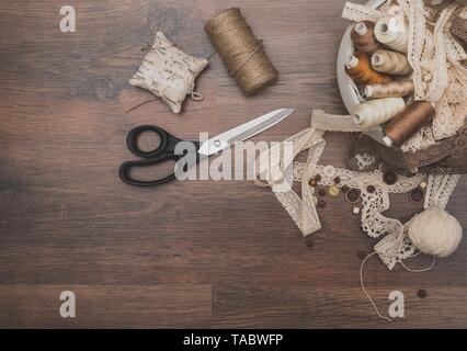 Sewing concept. Scissors, thread spools, buttons and sewing needles. Stock Photo