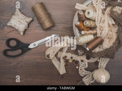 Sewing concept. Scissors, thread spools, buttons and sewing needles. Stock Photo