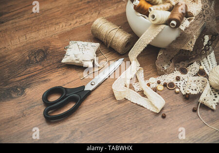 Sewing concept. Scissors, thread spools, buttons and sewing needles. Stock Photo