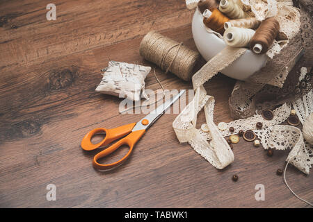 Sewing concept. Scissors, thread spools, buttons and sewing needles. Stock Photo