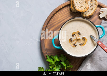 Delicious mushroom champignon soup on grey concrete table. Horizontal mockup, view from above. Space for text. Stock Photo