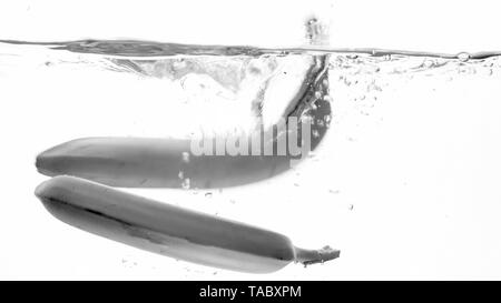 Closeup black and white image of fresh ripe banas falling and splashing. Tasty fruits floating in water Stock Photo