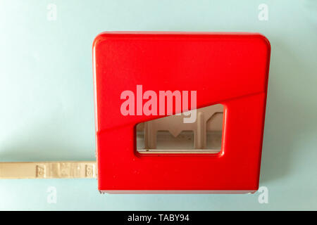 red hole punch on blue background in the office Stock Photo