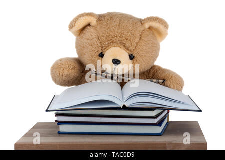 Teddy Bear sitting on the desk isolated on white background Stock Photo