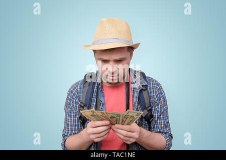 Young tourist man in summer hat holding dollars Stock Photo