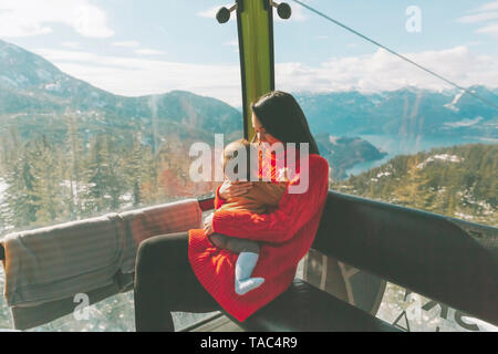 Mother holding her baby son in the gondola of a cable car, Squamish, Canada Stock Photo