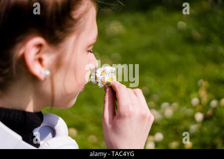 Young woman with daisies in a park Stock Photo