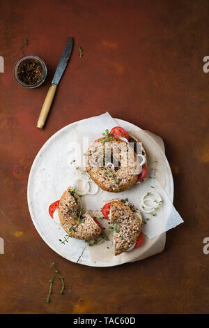 Bagels with sesame pesto, tomatoes, onions and thyme Stock Photo