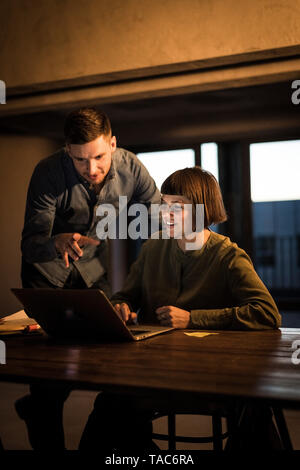 Colleagues sitting in office, working late Stock Photo