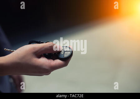 Hand pushing a car key button with copyspace Stock Photo