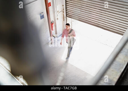 Bird's eye view of employee walking at loading bay in a factory Stock Photo