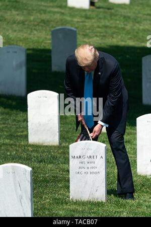 Arlington, Virginia, USA. 23rd May, 2019. United States President Donald J. Trump places a flag at a gravesite during the ''Flags-In' ceremony ahead of Memorial Day at Arlington National Cemetery, in Arlington, Virginia on May 23, 2019. ''Flags-In'' is an annual event where the 3rd U.S. Infantry Regiment, ''The Old Guard, '' places American flags at every gravesite at Arlington National Cemetery. Credit: Kevin Dietsch/Pool via CNP Credit: Kevin Dietsch/CNP/ZUMA Wire/Alamy Live News Stock Photo