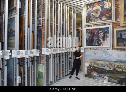 20 May 2019, Brandenburg, Beeskow: Florentine Nadolny, director of the art archive, stands in the 'heart' of the new depot with innumerable pulling grids to which pictures from GDR times are attached. 30 years after the fall of communism, GDR art is finding interest again, especially among those who did not experience this state for themselves. The Beeskow Art Archive wants to make a contribution to this with its new open depot. It has around 23,000 GDR commissioned works of art in its inventory, which are now more easily accessible. The art archive is scheduled to open on 29.05.2019. Photo: P Stock Photo
