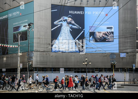 Milan, Italy. 24th May, 2019. People walk past a giant billboard promoting the new Huawei P30 and P30 Pro Android smartphones. Credit: Piero Cruciatti/Alamy Live News Stock Photo
