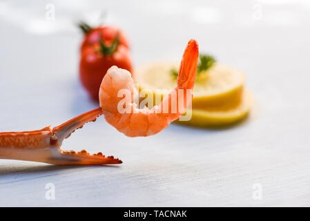 Shellfish seafood Shrimp on boiled crab claws / Shrimps prawns ocean gourmet dinner and tomato lemon on white table background Stock Photo