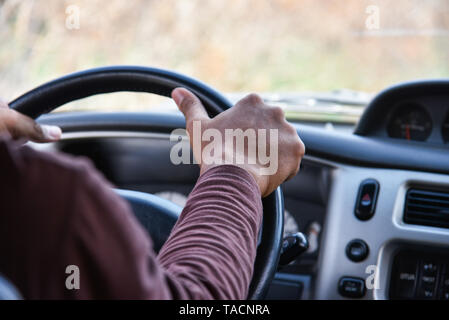 Man driving car / Driver hands on steering wheel driving my car on the road Stock Photo