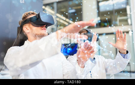 Two doctors using virtual reality glasses at visualization training for online investigation Stock Photo