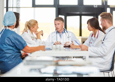 Senior doctor and his team with nurses in a meeting at the hospital Stock Photo