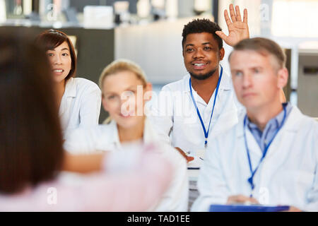 African medicine student in a seminar or lecture asks a question Stock Photo