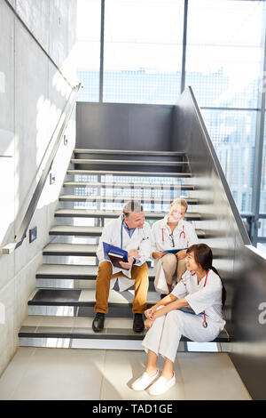 Senior doctor and nurse at the relaxed small talk in the stairwell of the clinic Stock Photo