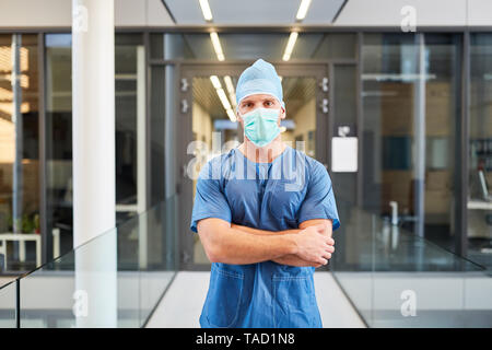 Young man as a surgeon with crossed arms in front of the emergency room in the clinic Stock Photo