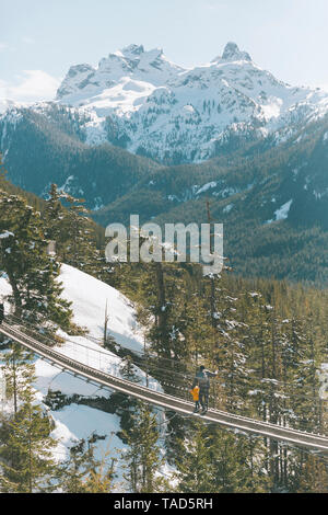 Father and son walking on a suspension bridge in the mountains, Squamish, Canada Stock Photo