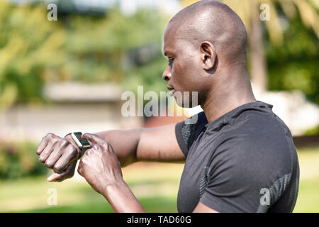 Runner checking smart watch fitness tracker Stock Photo
