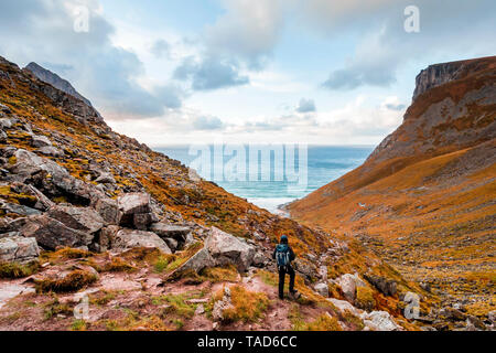 Norway, Lofoten Islands, hiker on the way to Kvalvika Beach Stock Photo