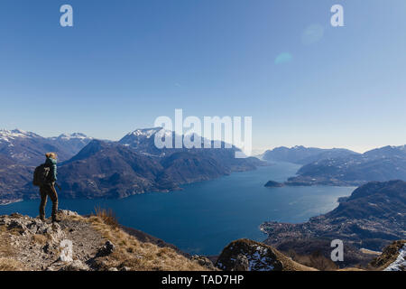 Italy, Como, Lecco, woman on a hiking trip in the mountains above Lake Como enjoying the view Stock Photo