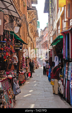 Handicrafts and souvenirs are for sale in a narrow alley off Durbar Square, Bhaktapur, Kathmandu Valley, Nepal Stock Photo