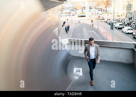 Businessman walking on overpass in the city Stock Photo