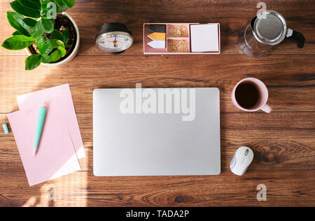 Closed laptop, coffee mug and other utensils on desk at home office, top view Stock Photo